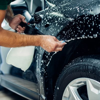 worker disperses soapy water in exterior detailing process at CT Detailing Louisville KY worker disperses soapy water in exterior detailing process at CT Detailing Louisville KY